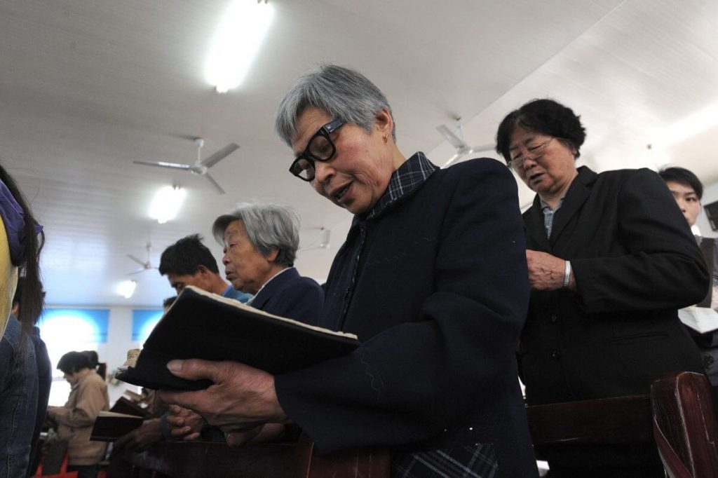 Mujeres chinas leyendo sus biblias durante un servicio.