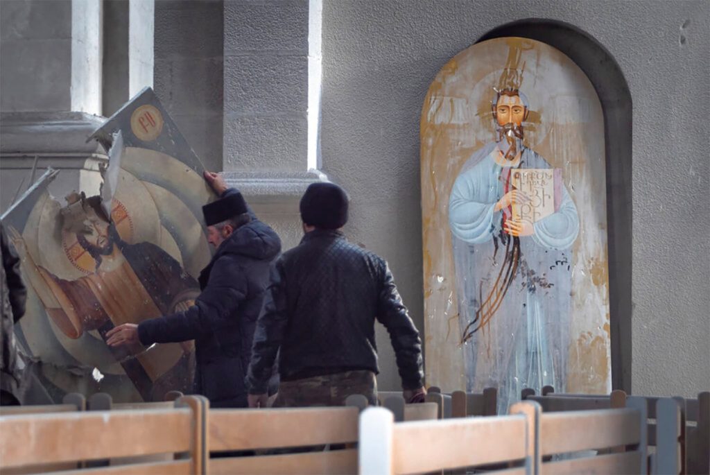 Hombres levantan un icono en la catedral del Santo Salvador dañada por los bombardeos durante un conflicto militar, en Shushi, en las afueras de Stepanakert, autoproclamada República de Nagorno-Karabaj el 8 de octubre