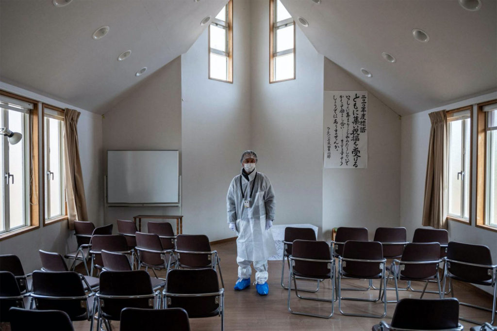 El reverendo Akira Sato con un traje protector mientras se encuentra en la capilla abandonada de la antigua Primera Iglesia Bautista Bíblica de Fukushima. 