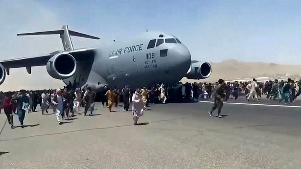Civiles tratando de subir a un avión de la Fuerza Aérea de los Estados Unidos en el aeropuerto de Kabul.